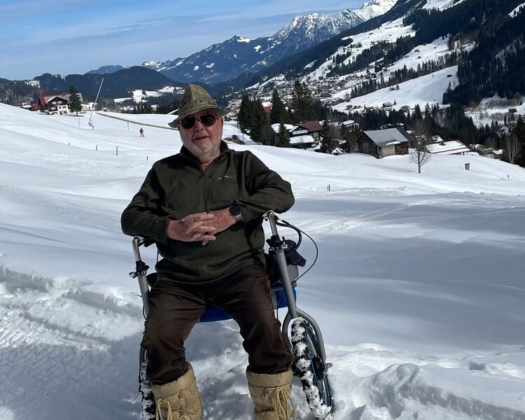 Mann sitzt vor Bergpanorama auf dem Wissel Alpin